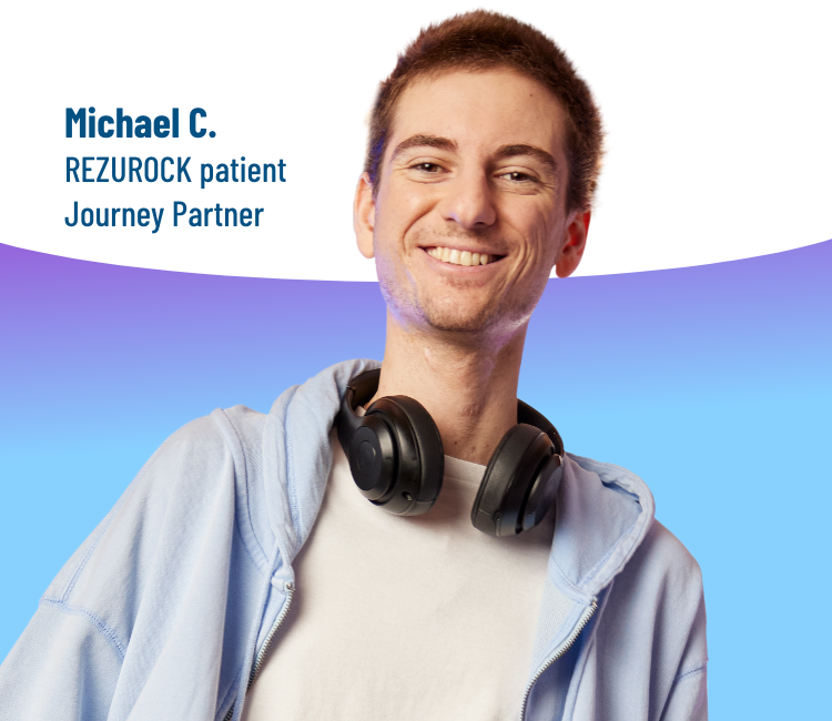 A man standing with headphones on his neck